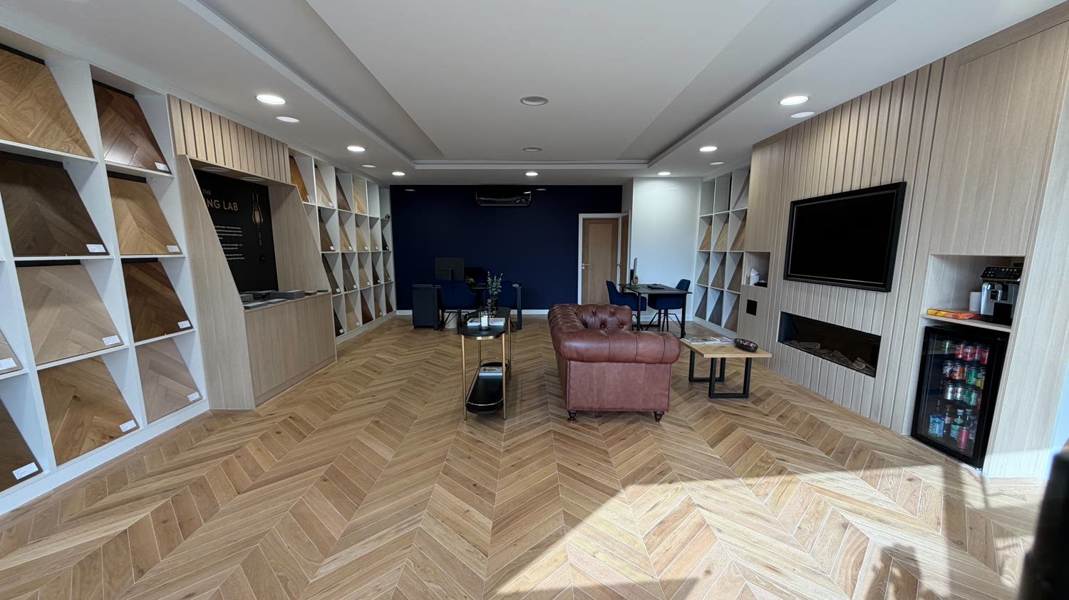 The interior of the Hampton Hill Flooring showroom at 4 Park Road, TW12 1HB &mdash; chevron oak floor and wood-panelled display walls